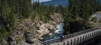 Biking on a trestle bridge on the Kettle Valley Trail in Christina Lake |