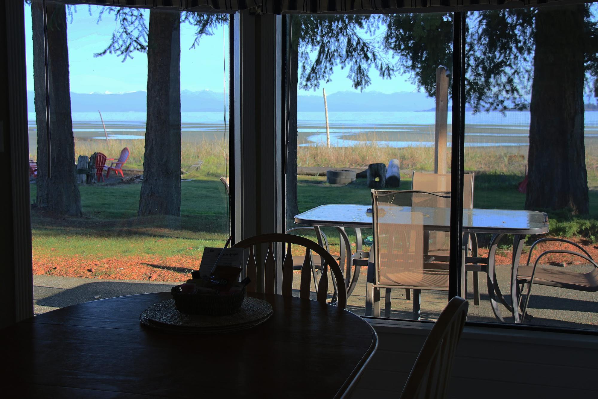 The view from the window of a beach-front accommodation looks out over the water.