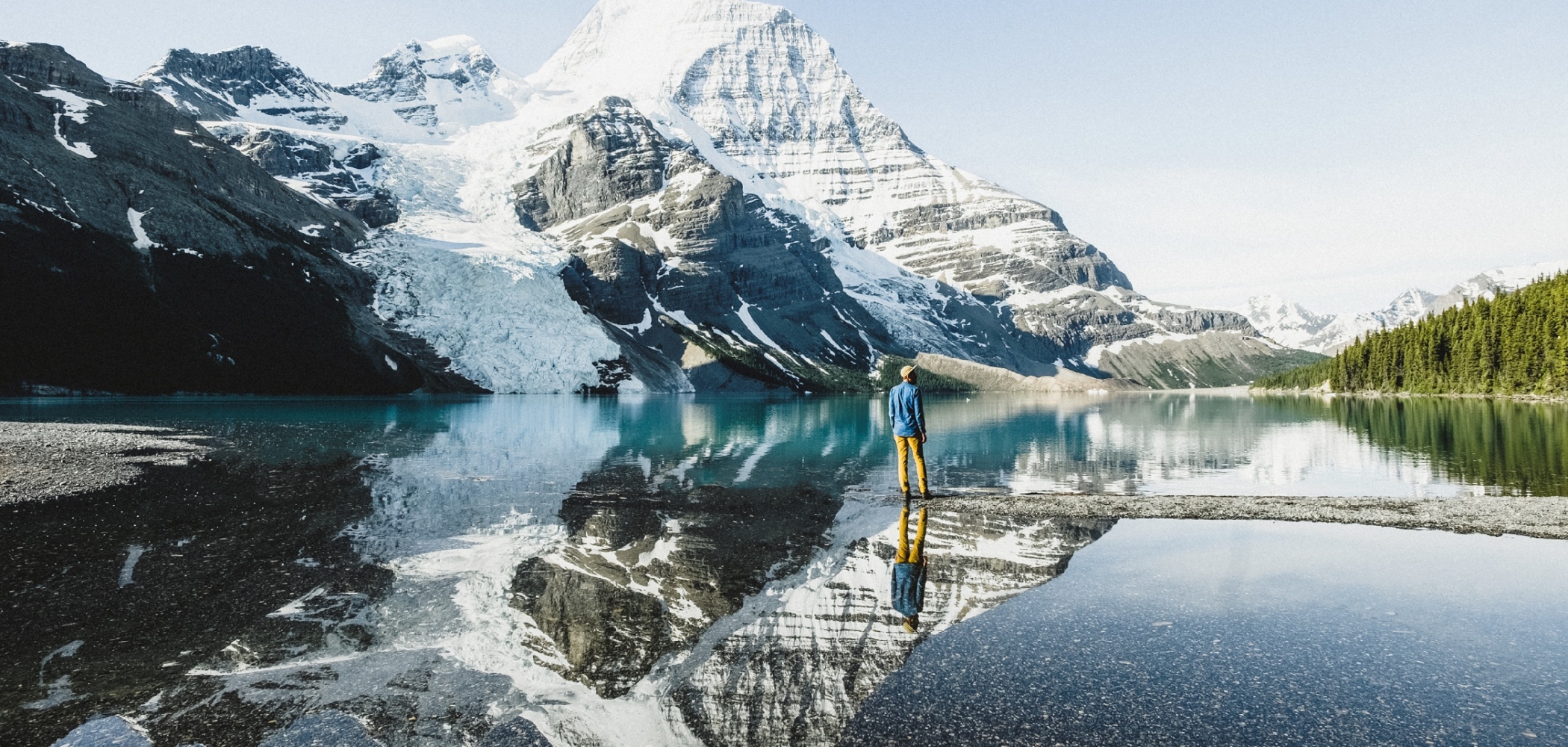 A person stands by a lake in Mount Robson Provincial Park