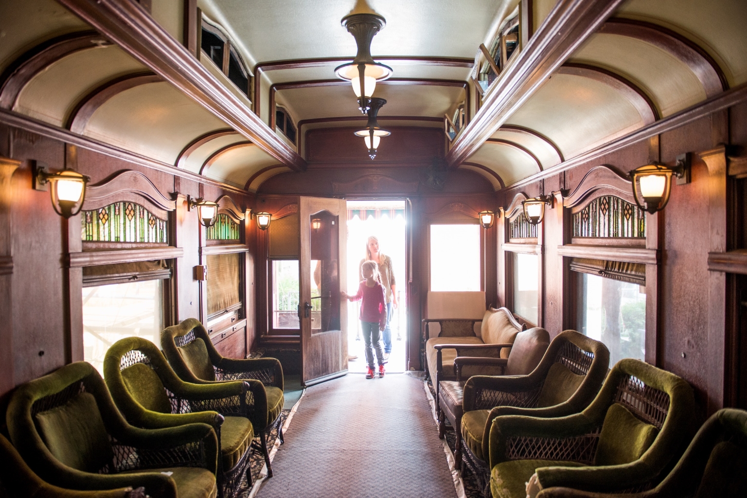 An adult and child open the door to the The Canadian Museum of Rail Travel in Cranbrook