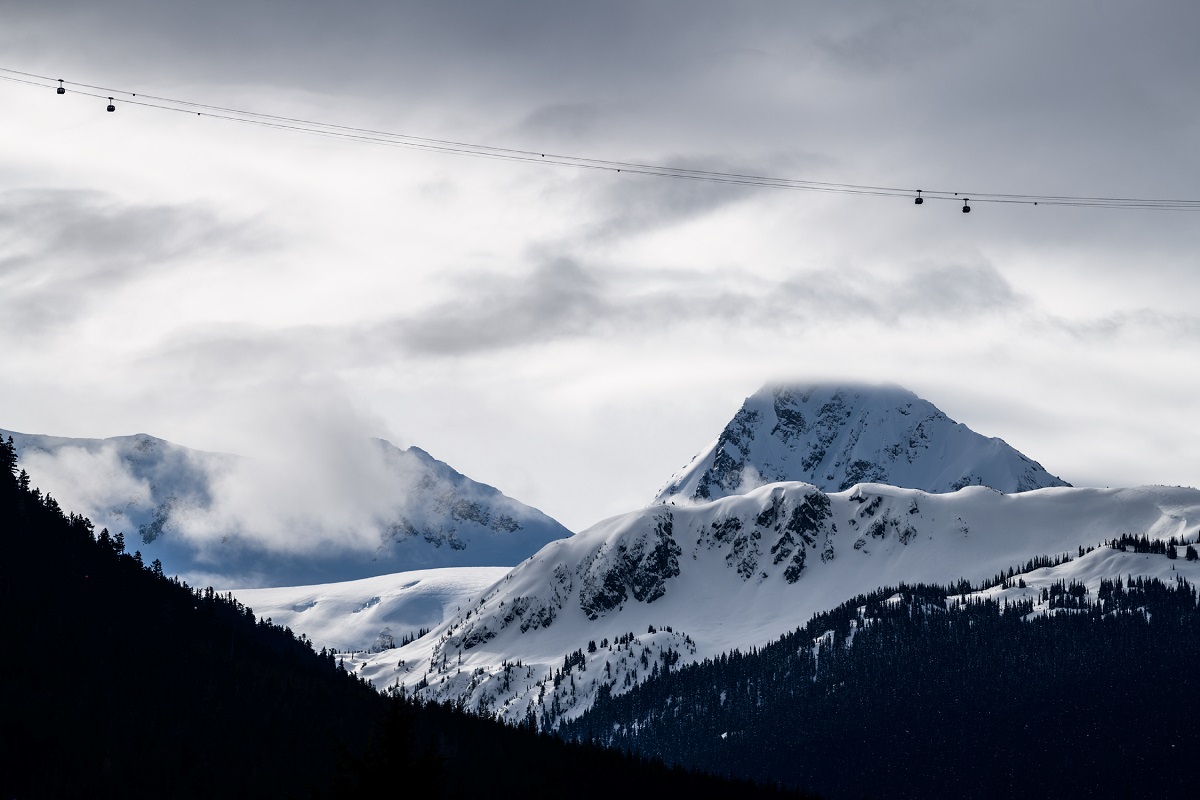 A view of the mountains with four Peak 2 Peak Gondolas crossing the valley in the distance.