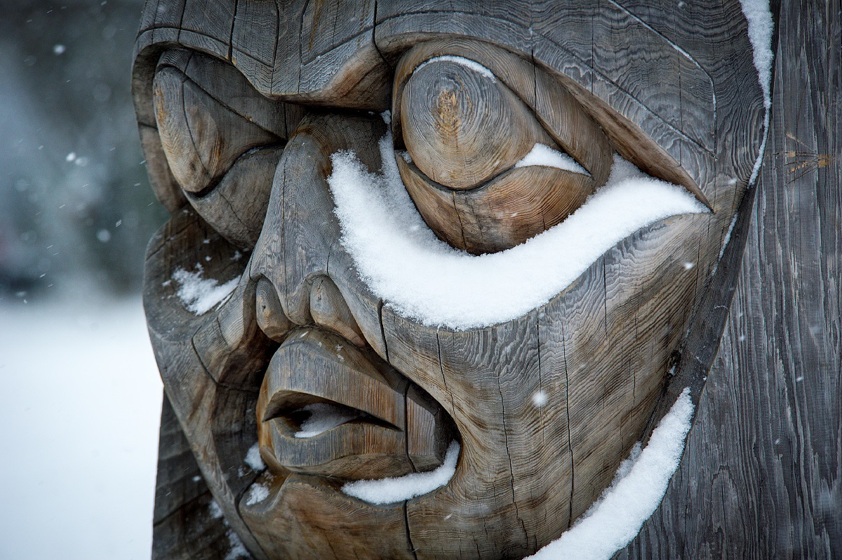 Close up of a totem pole with snow