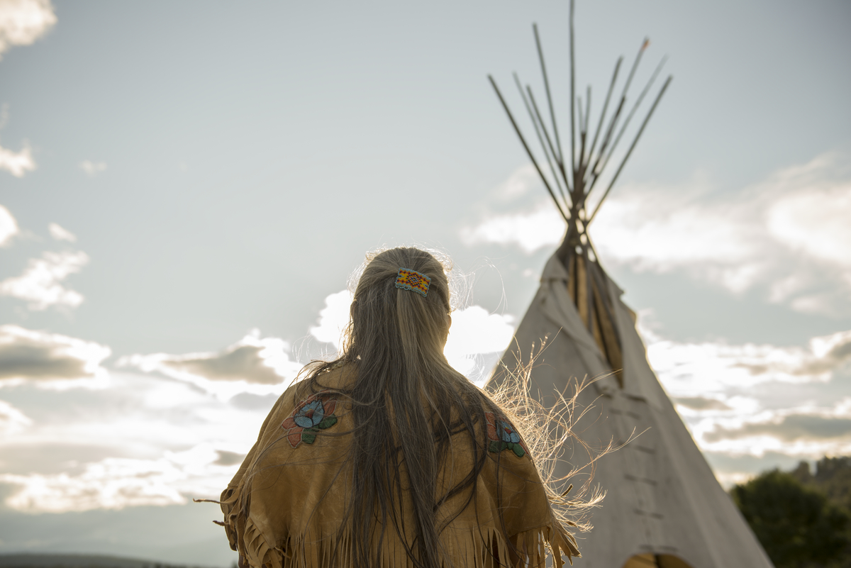 Ktunaxa elder in regalia next to a teepee at St Eugene Golf Resort in the Kootenay Rockies