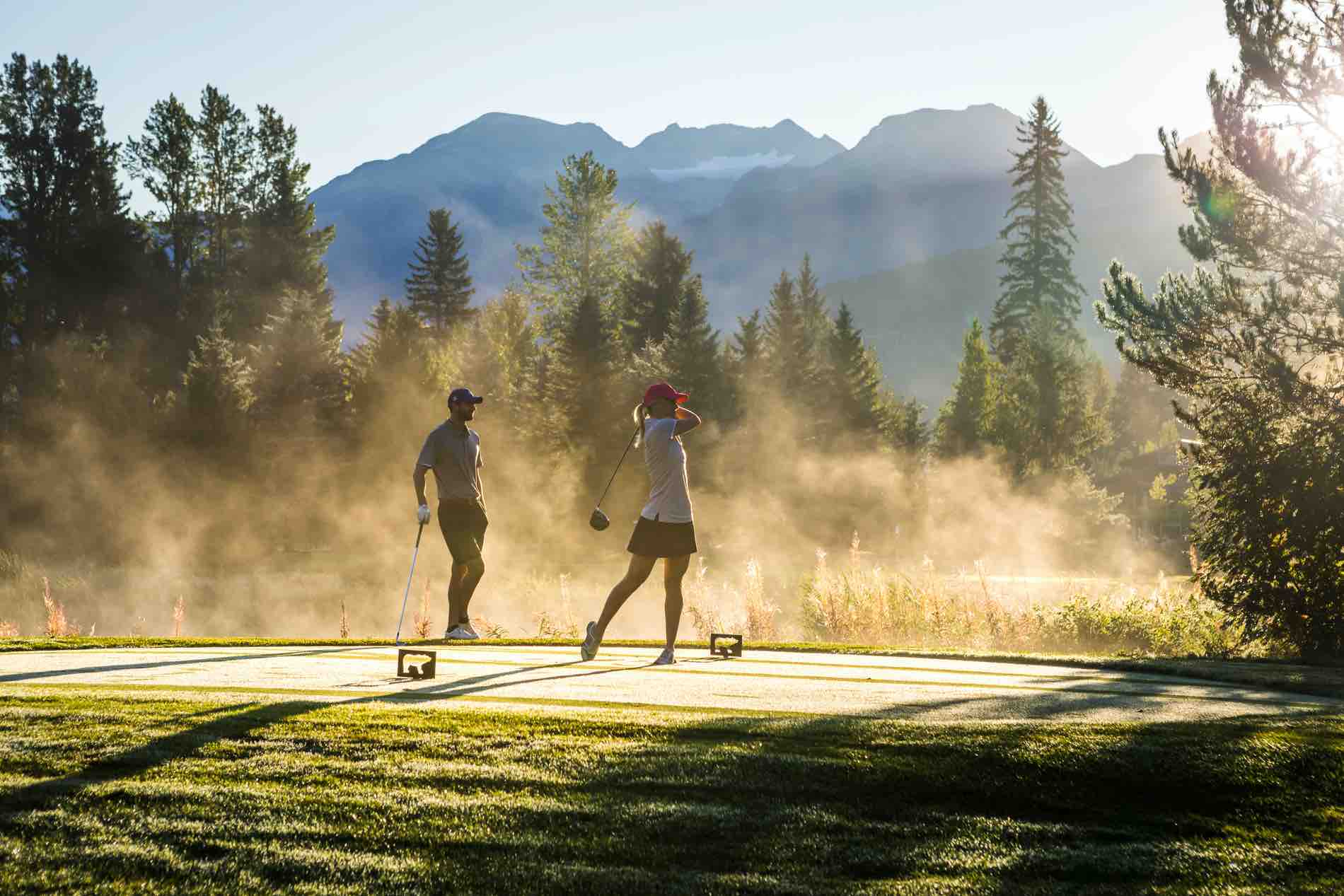 Two golfers tee off in then early morning at Nicklaus North Golf Course. The morning dew is burning off in the sun.