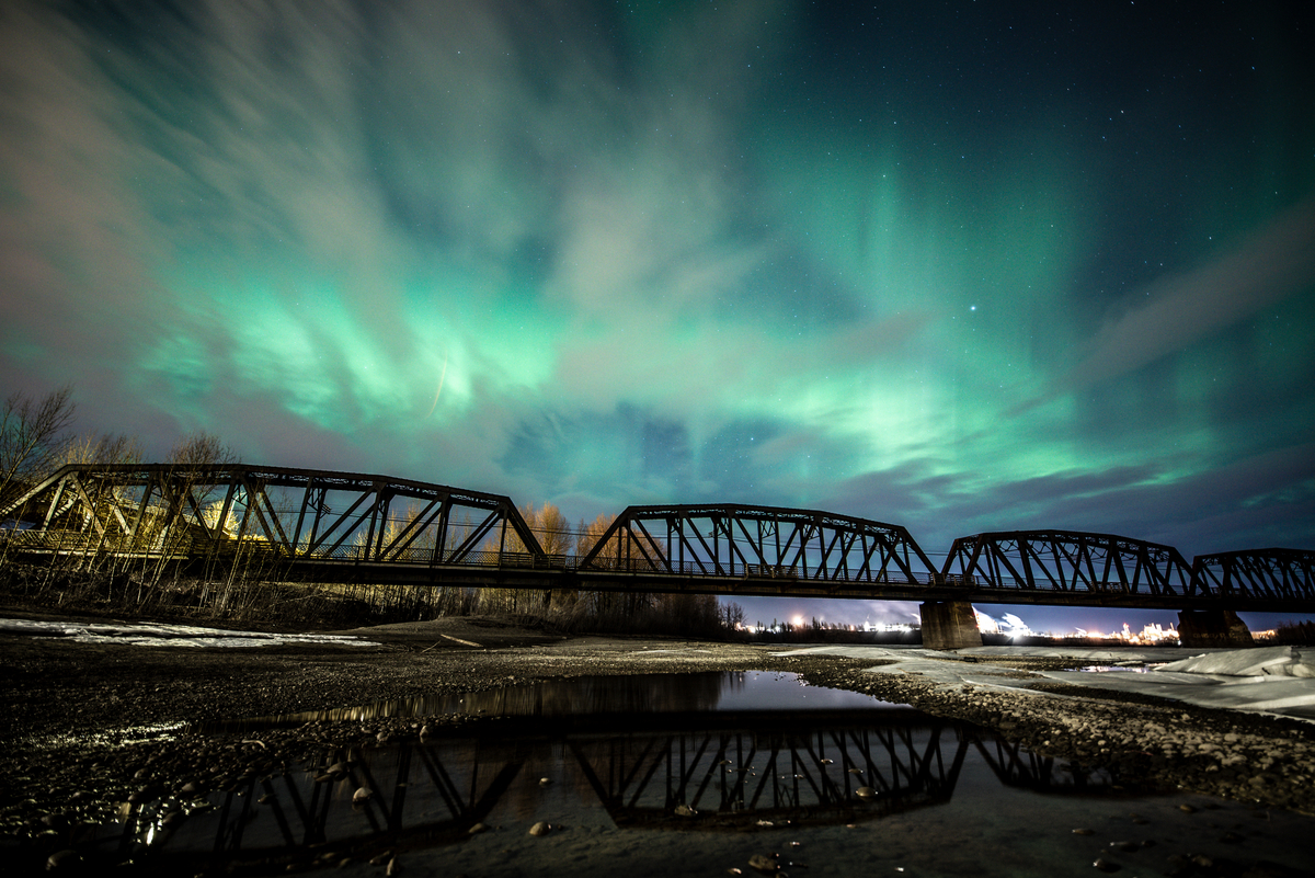 The Northern Lights are seen over an old train bridge in Prince George