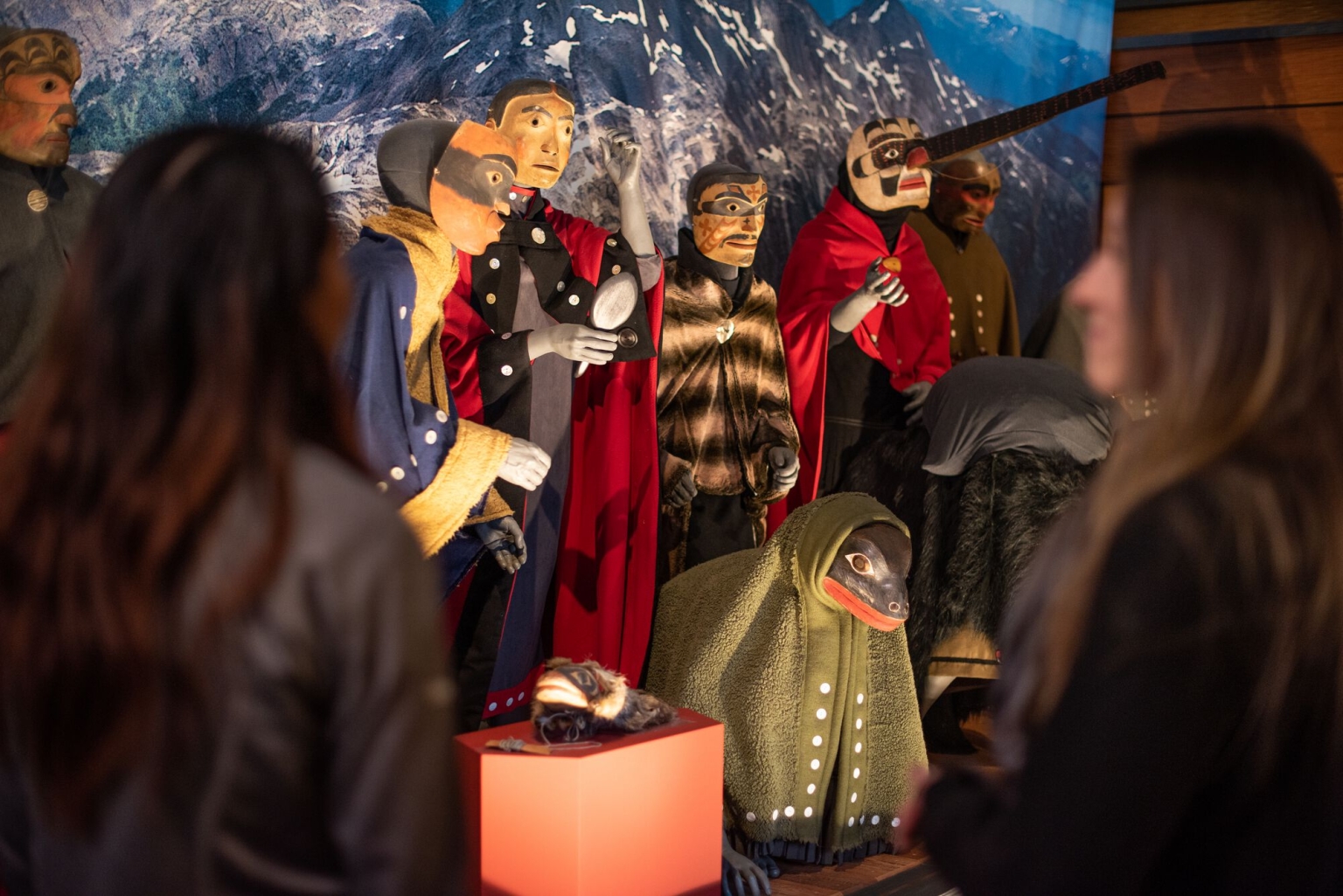 People stand in front of an Indigenous exhibit 