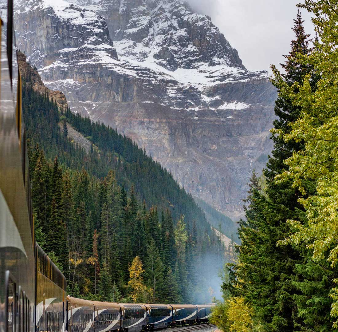 Rocky Mountaineer luxury train rounding a corner through the mountain pass. 